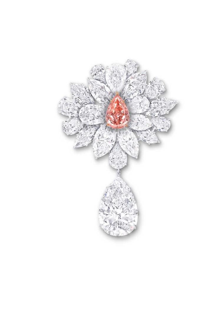 Graff's Diamond Flower Brooch features an 8.97ct pear-shaped Fancy Vivid Pink Orange diamond, surrounded by a spray of white diamond petals and leaves. The brooch is further enhanced with a 38.13ct D Flawless pear-shaped white diamond suspended from a lea